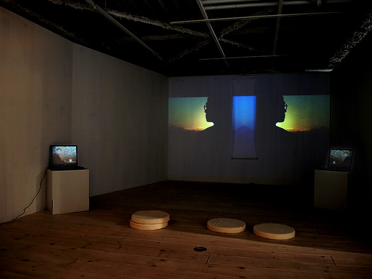 installation view with projection on the wall and 2 computers