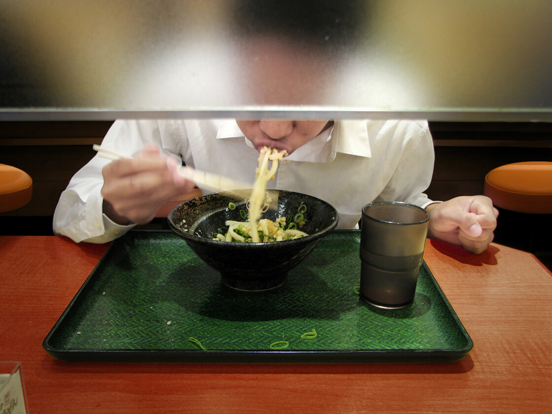 a salaryman eating udon noodles in Shibuya