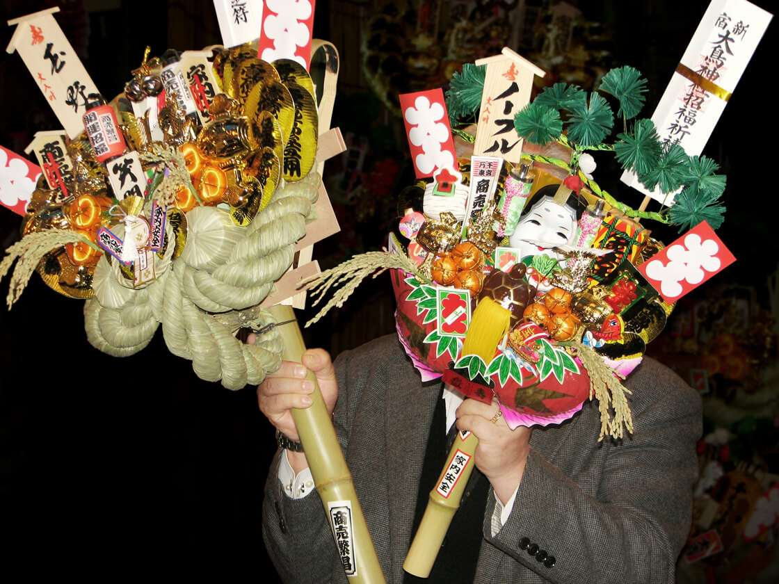 a salaryman holding Kumade (rake) in Hanazono shrine for tori no ichi festival